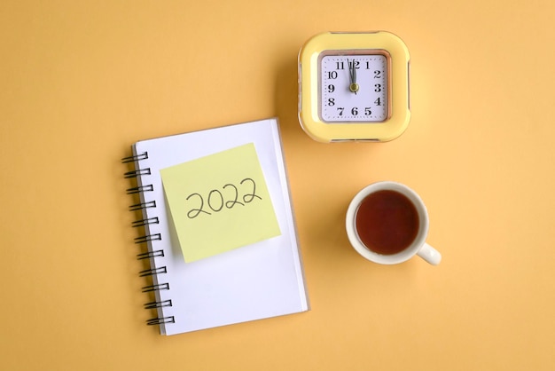 2022 on notepad with clock and cup of coffee