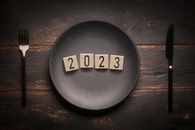 2023 concept the new year 2023 figures on cubes on a black plate in a restaurant invitation to a holiday a festive event