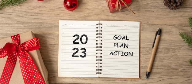 2023 Goal Plan Action with notebook Christmas gift and pen on wood table Xmas Happy New Year Resolution To do list start and Strategy concept