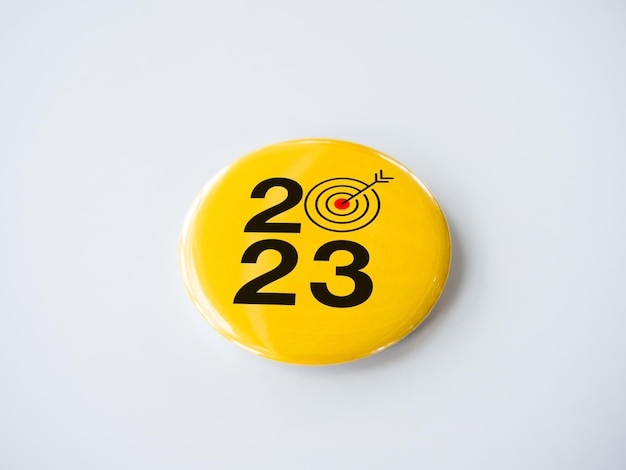 2023 Happy New year background Business goal with year numbers and red target bullseye icon sign on yellow round badge pin isolated on white background Welcome Merry Christmas Happy New Year 2023