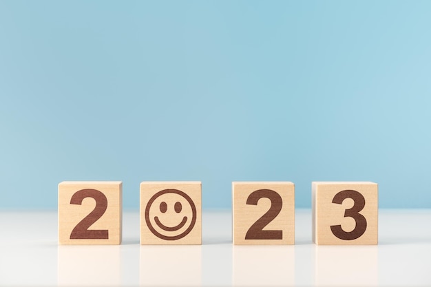 2023 happy new year Wooden cube block with 2023 and smile happiness good luck fun in the coming year 2023 copy space blue background