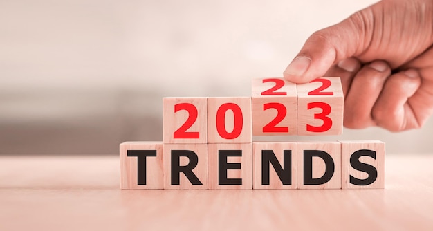 2023 trend concept Hand flip wood cube change year 2022 to 2023