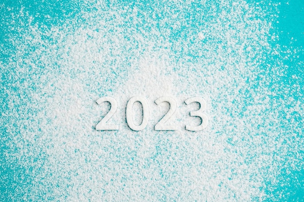 2023 white numbers and snow on blue background copy space New year concept