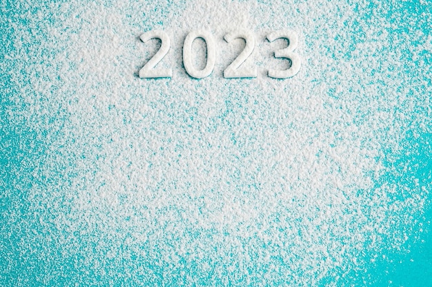 2023 white numbers and snow on blue background copy space New year concept