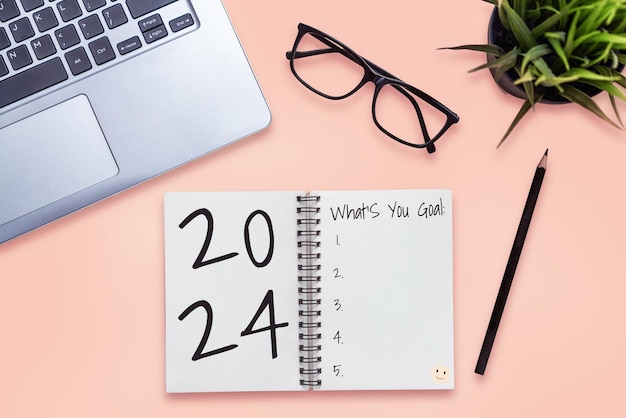 2024 Happy New Year Resolution Goal List and Plans Setting Business office desk with notebook written about plan listing of new year goals and resolutions setting Change and bliss concept