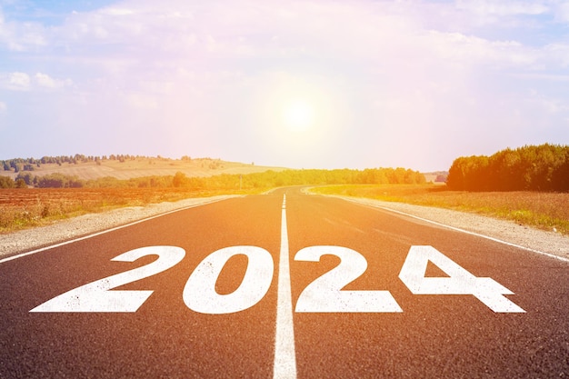 2024 written on highway road in the middle of empty asphalt road and beautiful blue sky.