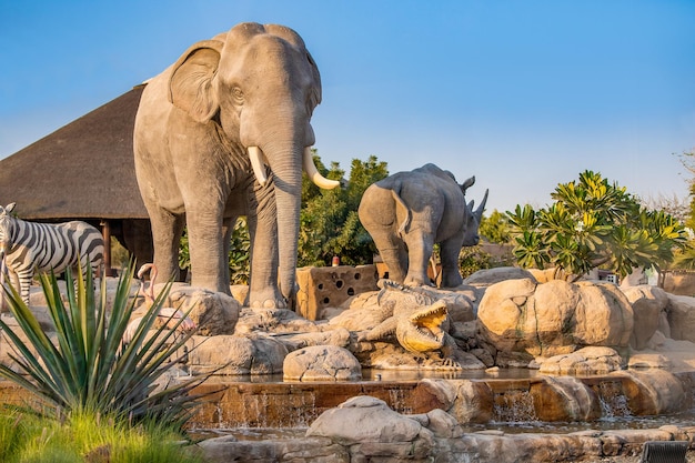 23 February 2021 Dubai UAE Zebra elephant and crocodile statues on an artificial fountain and waterfall in the central safari village at Dubai Zoo