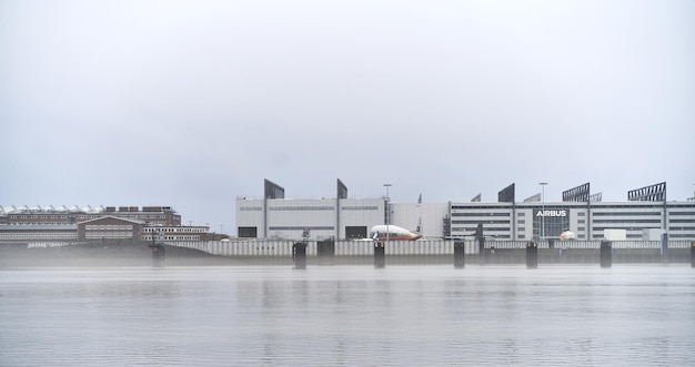 24122022 Hamburg Germany Airbus factory on the river Exterior view of the Airbus factory in HamburgFinkenwerder Big aircraft parts are in front of the building