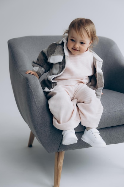 290422 Kyiv Ukraine little stylish girl of one and a half years poses for a photo on a white studio cyclorama