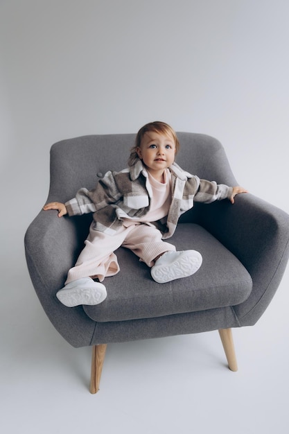 290422 Kyiv Ukraine little stylish girl of one and a half years poses for a photo on a white studio cyclorama