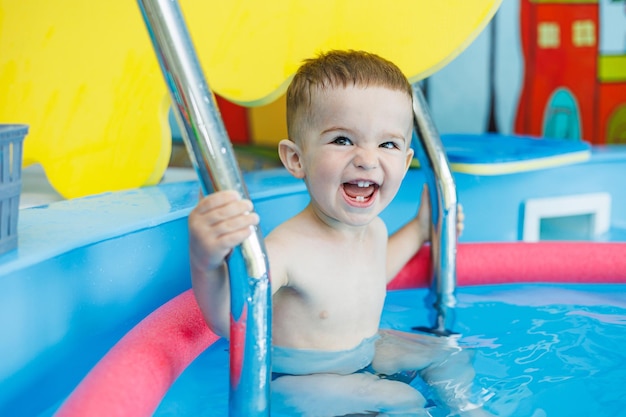 A 2yearold little boy learns to swim in a clean pool Child development Developmental pool for teaching children to swim Swimming school