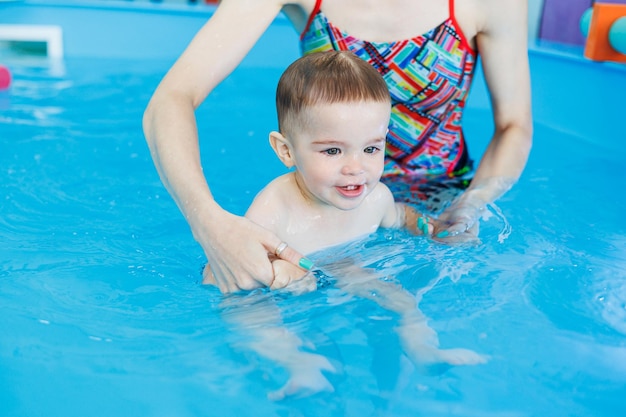 A 2yearold little boy learns to swim in a clean pool Child development Developmental pool for teaching children to swim Swimming school