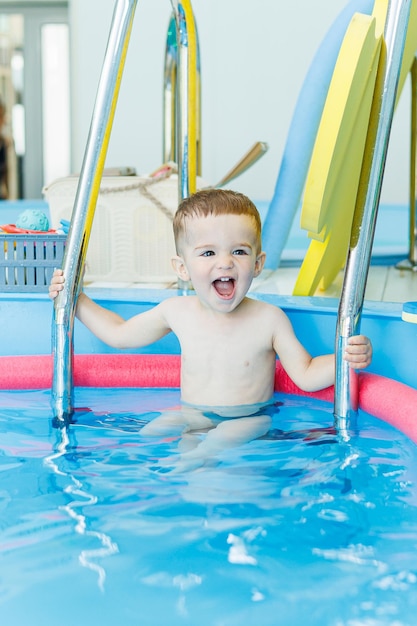 A 2yearold little boy learns to swim in a clean pool Child development Developmental pool for teaching children to swim Swimming school