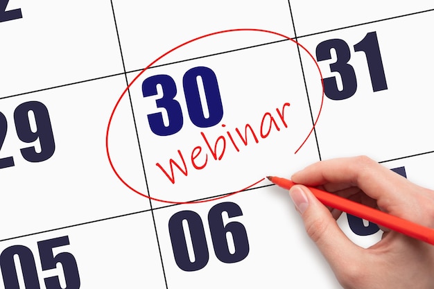 30th day of the month Hand writing text WEBINAR and circling the calendar date