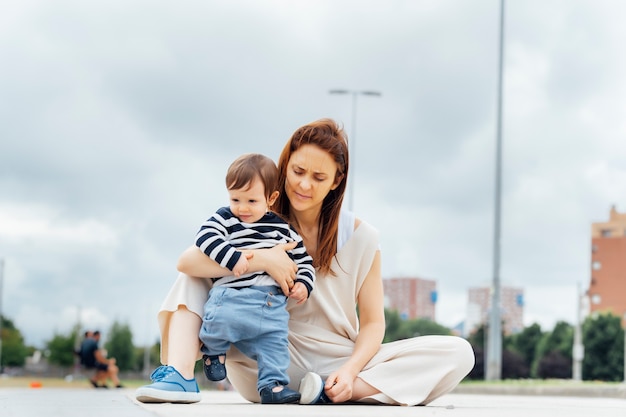 37-year-old mother with her baby of one on the street teaching him to walk