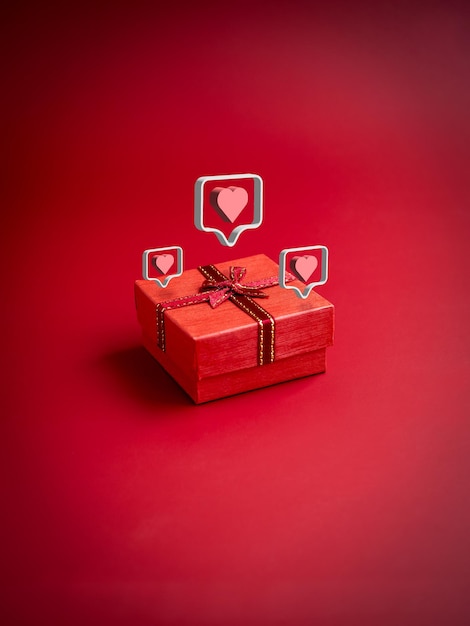 3d love like heart icons floating on small red present gift box with ribbon on red background vertical style Essential gift on special days birthdays New Years Valentine's Day and anniversaries