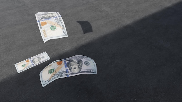 3d render. Falling 100 dollar bills. On the grey asphalt background.