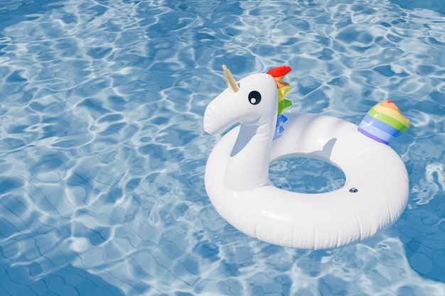 3D rendering of an inflatable unicorn float in a swimming pool with clear water summer concept