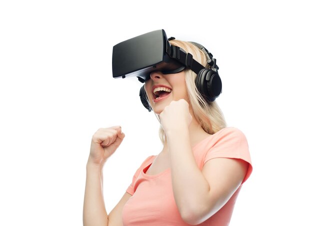 3d technology, virtual reality, entertainment and people concept - happy young woman with virtual reality headset or 3d glasses playing game and fighting