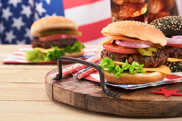 4th of July American Independence Day traditional picnic food American Burger and cocktail American flags and symbols of USA Patriotic picnic holiday on white wooden background Top view