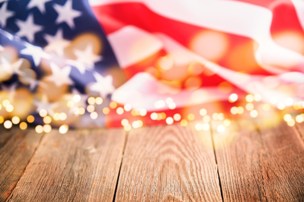 4th of July background Empty wooden plank table with American USA flag and burning sparkler fireworks and golden lights bokeh Happy Labor Independence or Presidents Day American flag colors