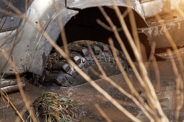 4x4 SUV is stuck in the mud Wheels of the SUV are in dirty water