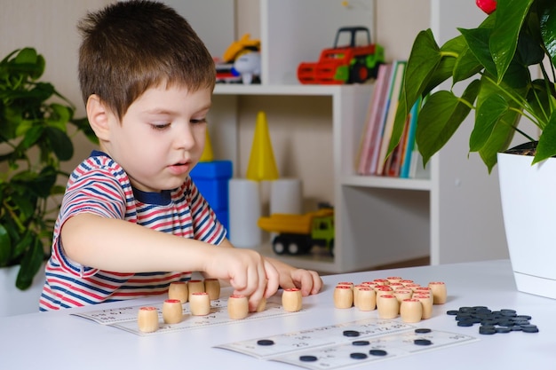 A 4yearold boy plays loto studies numbers using a board game