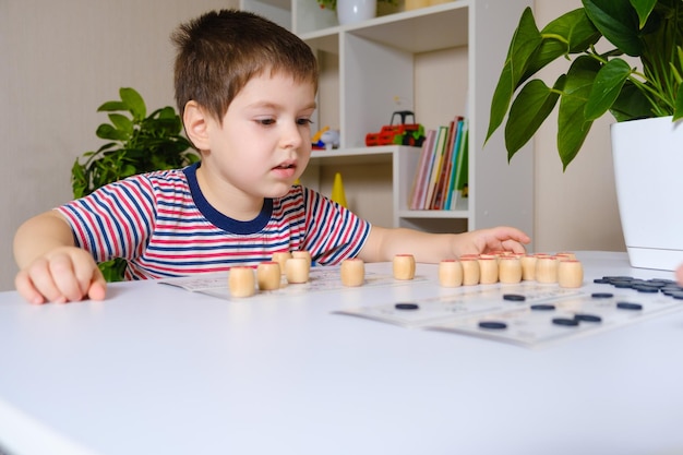 A 4yearold boy plays loto studies numbers using a board game