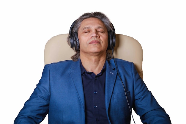 50yearold man listens to music on headphones at home sitting in a chair