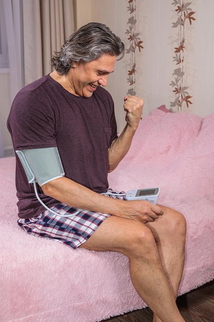 A 50yearold man measures his blood pressure with a tonometer