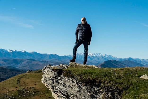 60 years old man posing after a mountain walk in north Spain with a beautiful nature landscape