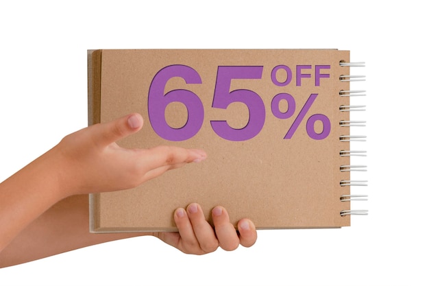 65 percent discount on isolate Notepad from recycled paper in the hands of a child with text sale up to 65 percent The child is holding a notepad demonstrating a big sale