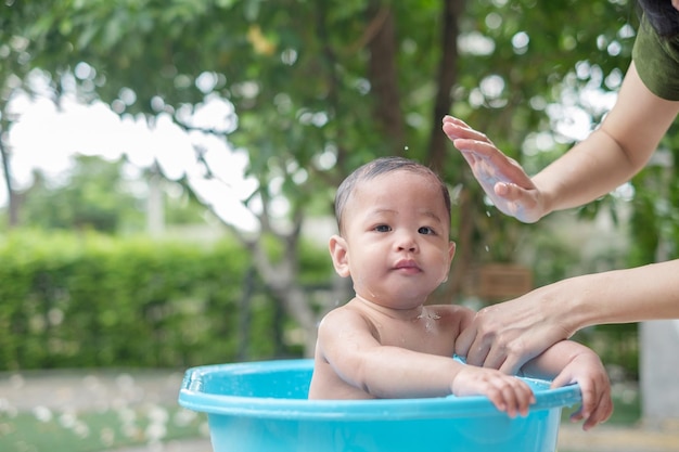 7 month old baby taking a bath in a good mood outdoors