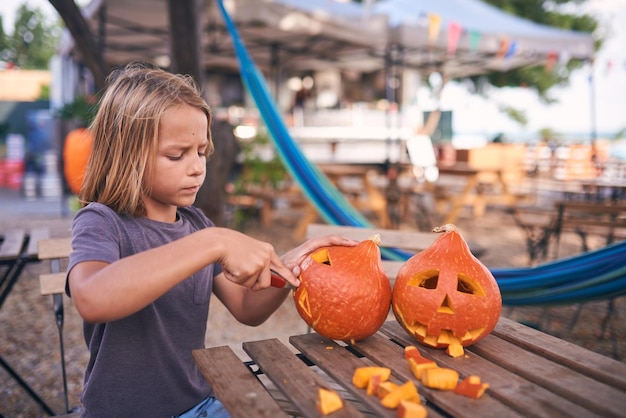 8 year old boy carving Halloween pumpkin