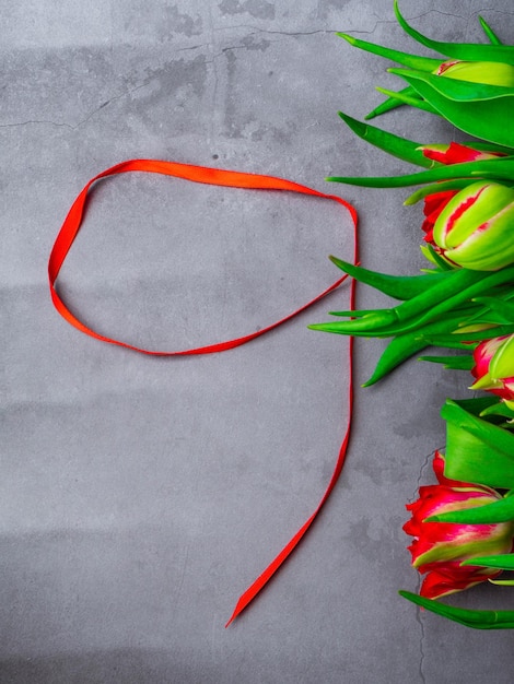 9 May background red tulips and red ribbon on the concrete background free space for text