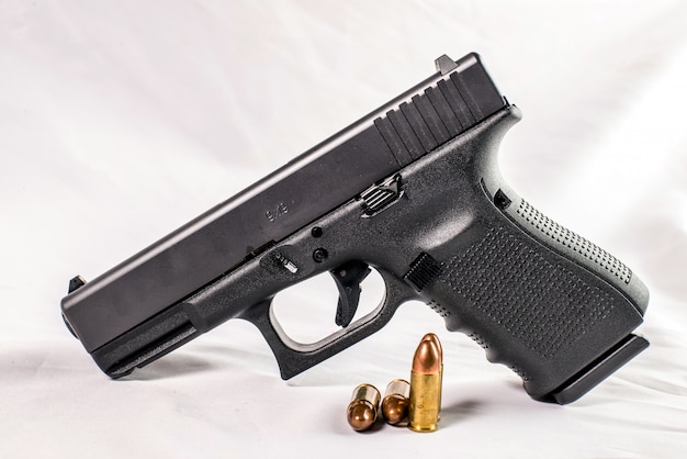 9 mm pistol gun and bullets strewn with ammunition on wooden background