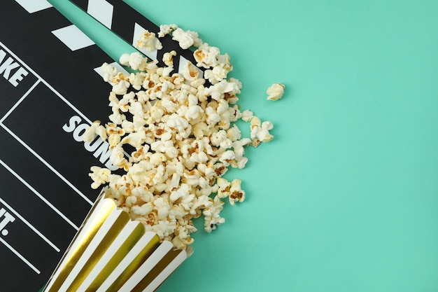 ÃÂ¡lapperboard and paper box with popcorn on mint background.