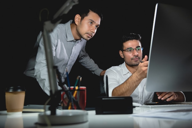 Aasian businessman coworkers discussing work at night