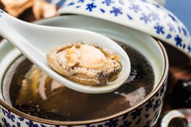 Photo abalone and morel chinese soup on a bowl