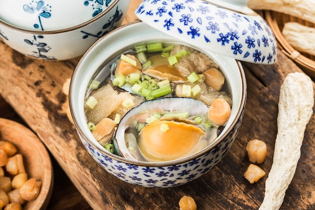 Photo abalone and morel chinese soup on a bowl