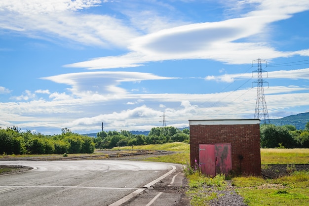 An abandoned building on the side of a road.