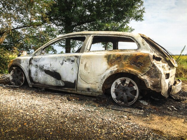 Photo abandoned burnt car at isolated field