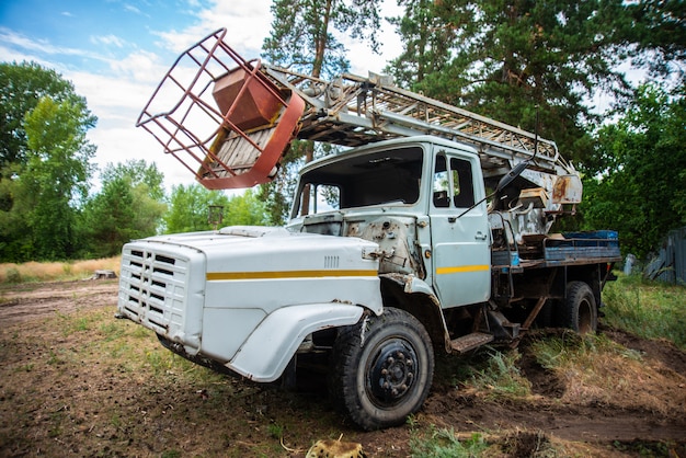 Abandoned old truck in a clearing, grunge equipment, disassembled broken