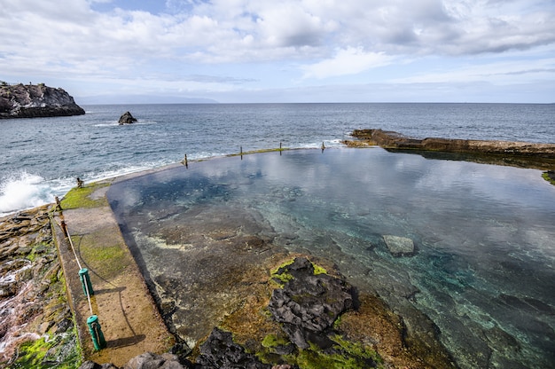 An abandoned outdoor pool with ocean water on a volcanic coast. Selective focus.  Los Gigantes, Tenerife