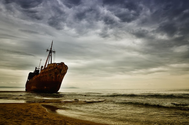 Photo abandoned sailboat on sea shore against sky