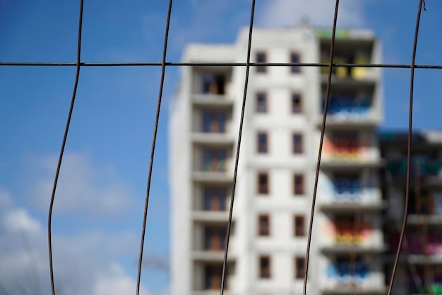 Abandoned unfinished residential building closeup on a fence bokeh effect