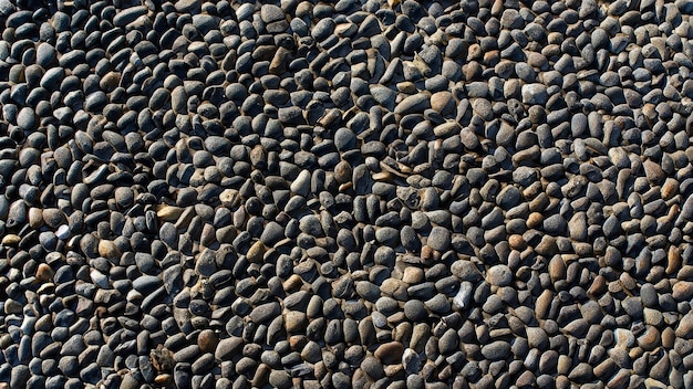 Abstract background of black pebble stones arranged on black surface