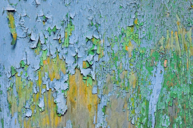 Abstract background of cracked weathered old wood with layers of paint