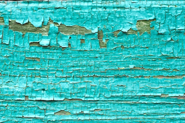 Abstract background of cracked weathered old wood with layers of paint