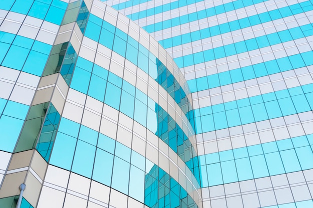 Abstract background from blue glasses window in modern building with sky and clouds reflection.